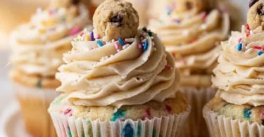 Delicious cookie dough cupcakes topped with creamy frosting and cookie pieces