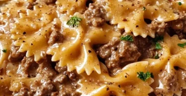 Delicious creamy beef pasta served in a bowl with fresh herbs.