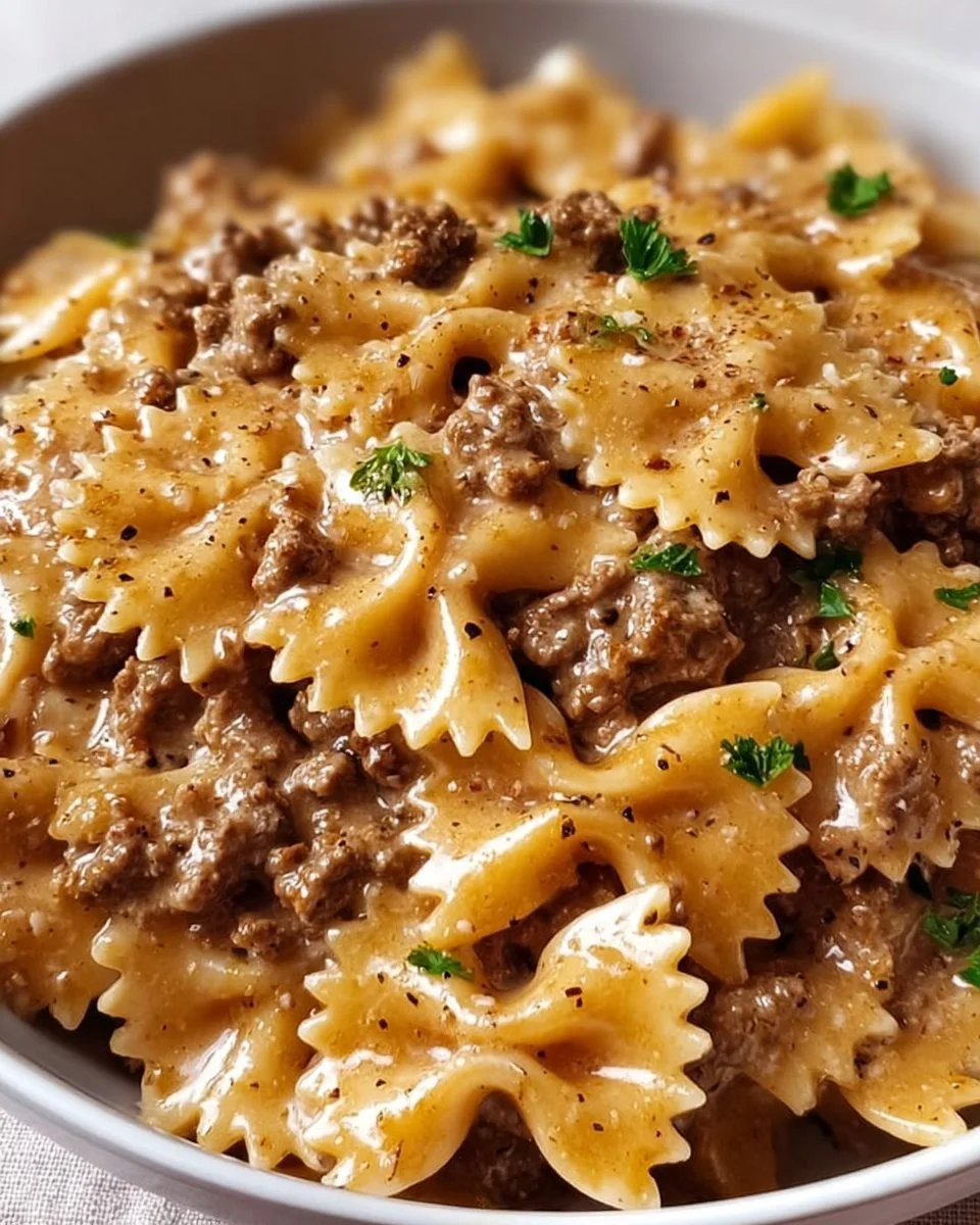 Delicious creamy beef pasta served in a bowl with fresh herbs.