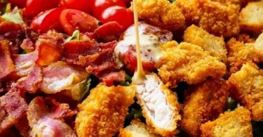 Crispy Chicken BLT Salad with greens, bacon, and grilled chicken on a plate.