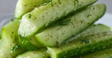 Delicious Garlic Dill Cucumbers in a bowl garnished with herbs