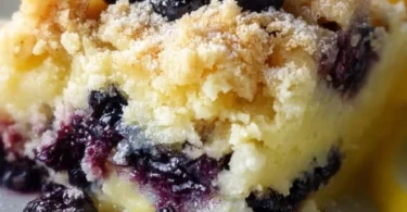 Lemon Blueberry Cheesecake Dump Cake topped with fresh blueberries and lemon zest