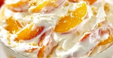 Delicious Peach Cheesecake Salad topped with fresh peaches and creamy cheesecake