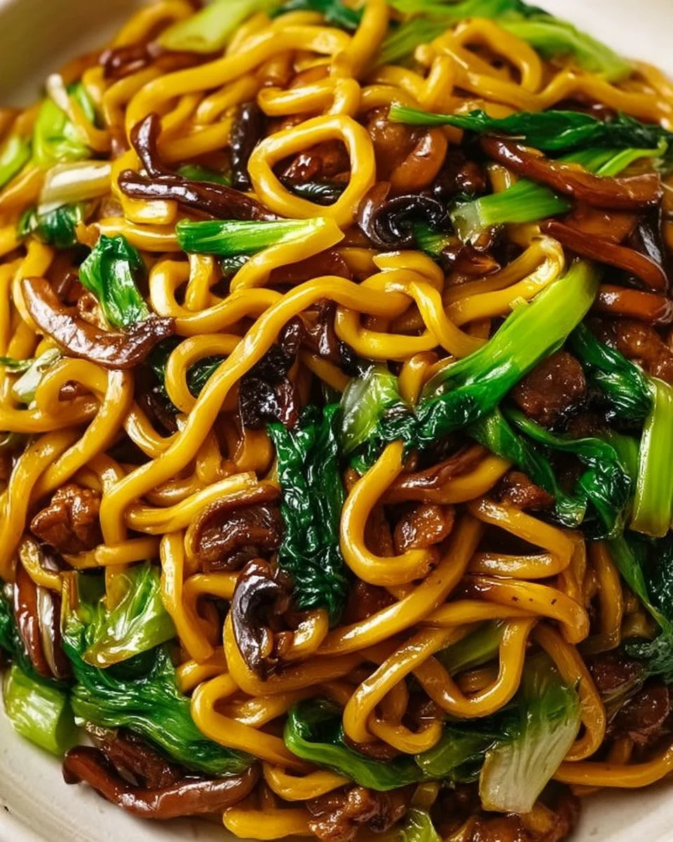 Plate of savory Shanghai fried noodles with colorful vegetables and proteins.