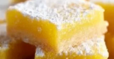 Delicious super easy lemon bars on a plate with lemon slices.